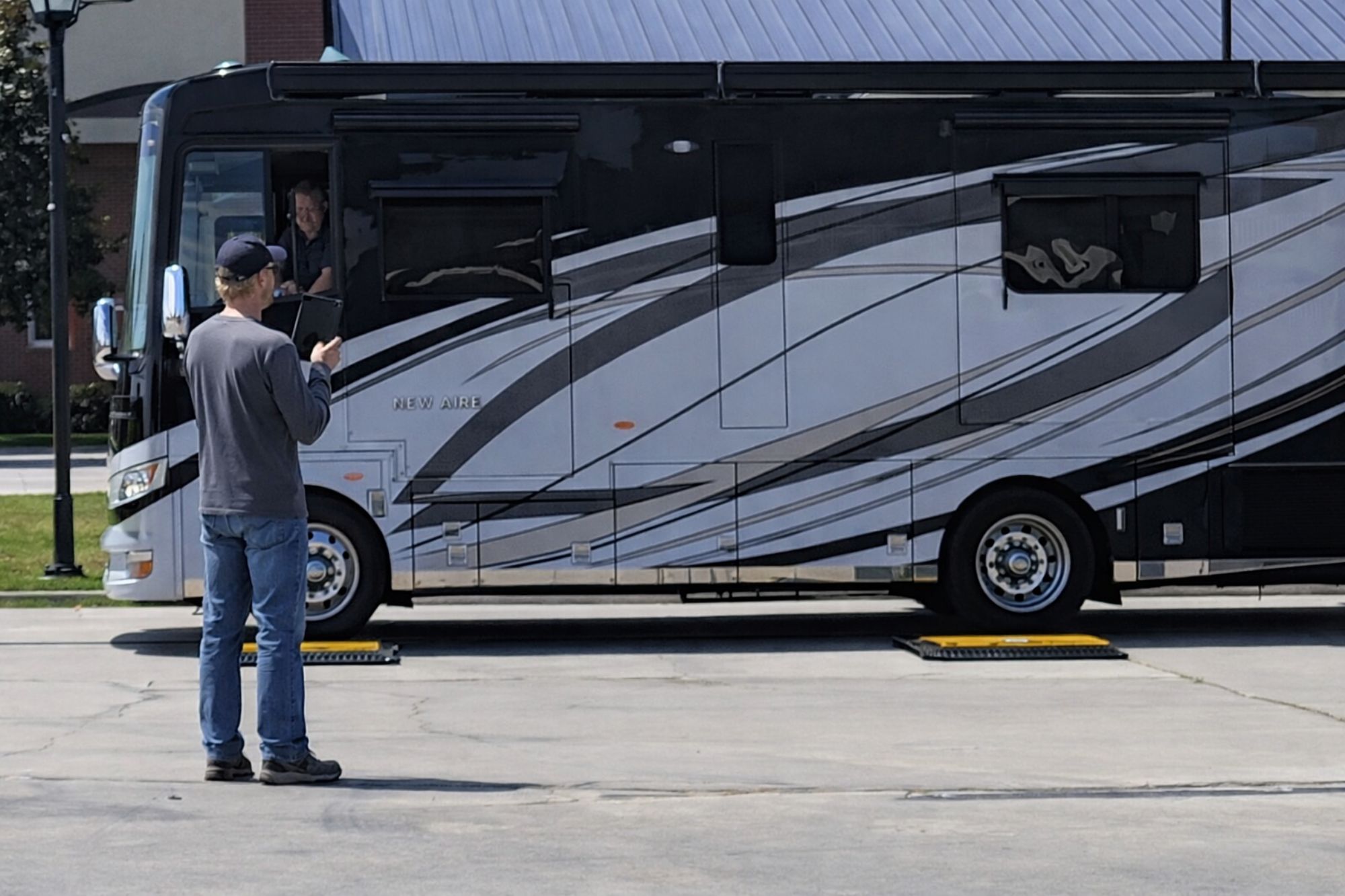 Technician recording individual wheel weights during RV weighing